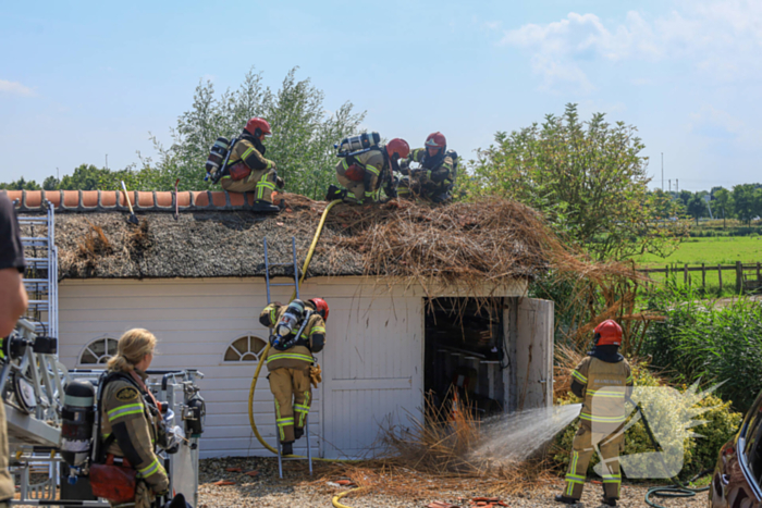 Brandweer blust brand in rietenkap van woning