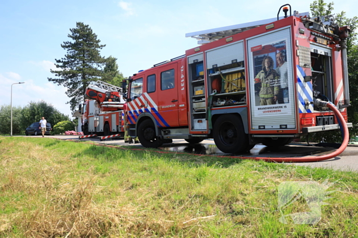 Brandweer blust brand in rietenkap van woning