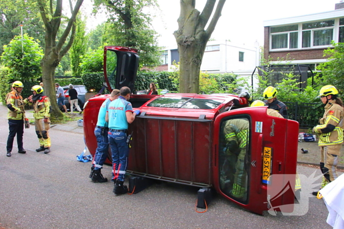 Auto belandt op zijkant na botsing tegen boom