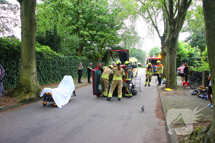 Auto belandt op zijkant na botsing tegen boom