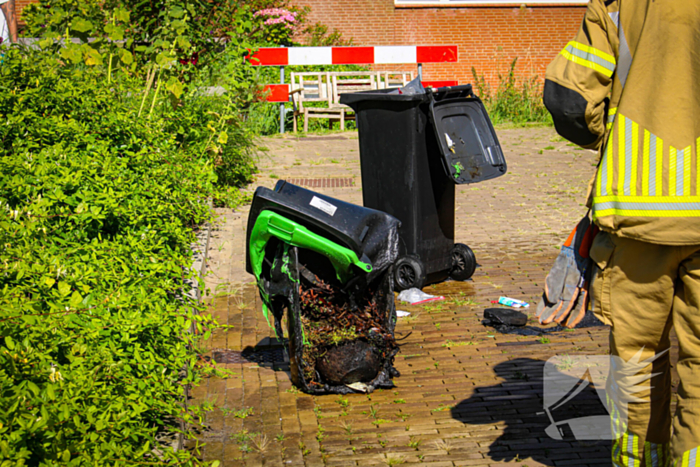 Afvalbak vat vlam bij woning