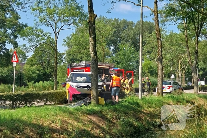 Elektrische bedrijfsbus raakt van de weg en belandt tegen boom