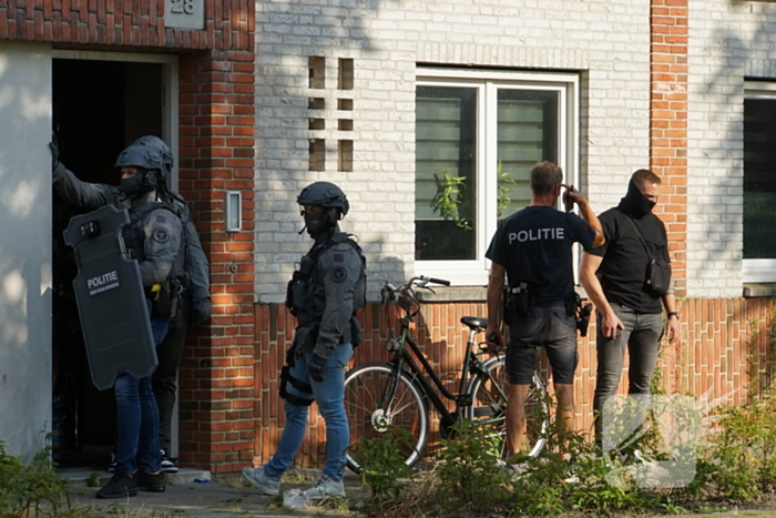 Agenten in kogelwerende vesten en Dienst Speciale Interventies bij inval in woning