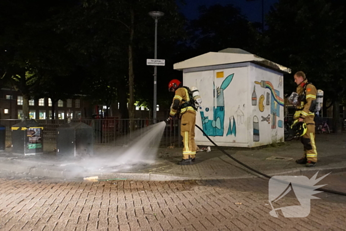 Brandweer blust brand naast afvalcontainer