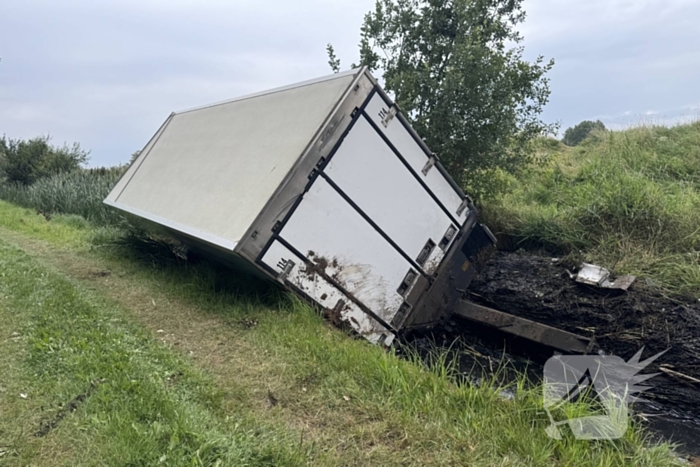 Vrachtwagen belandt in sloot naast snelweg, chauffeur ongedeerd