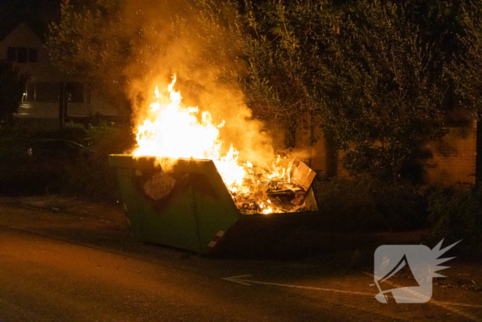 Metershoge vlammen door containerbrand