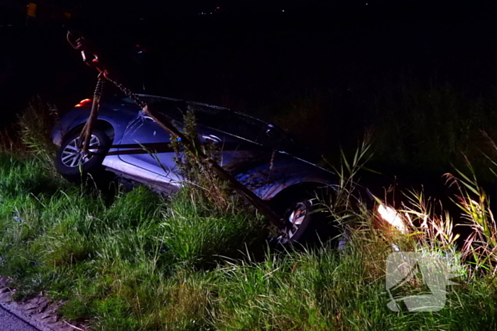 Auto vliegt uit de bocht en belandt ondersteboven in sloot