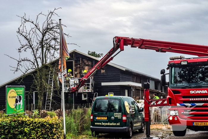 Brandweer blust brandende tussenmuur bij kaasboerderij