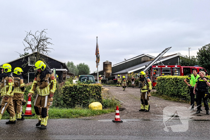 Brandweer blust brandende tussenmuur bij kaasboerderij