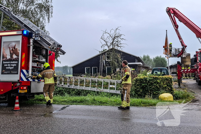 Brandweer blust brandende tussenmuur bij kaasboerderij