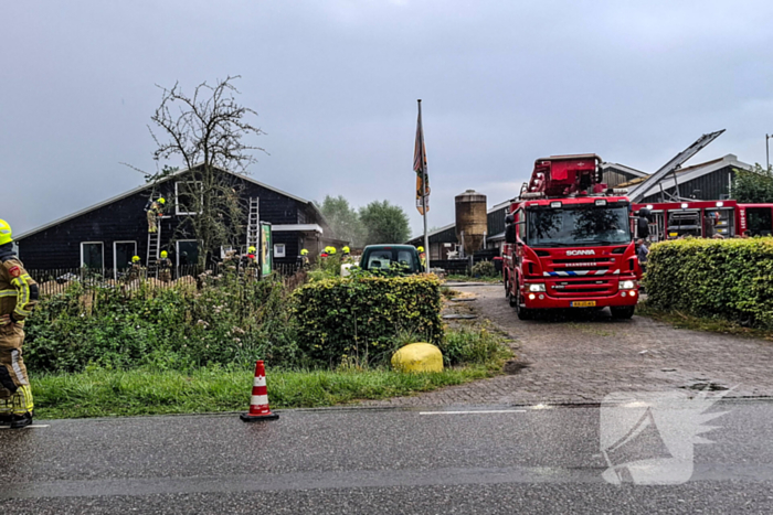 Brandweer blust brandende tussenmuur bij kaasboerderij