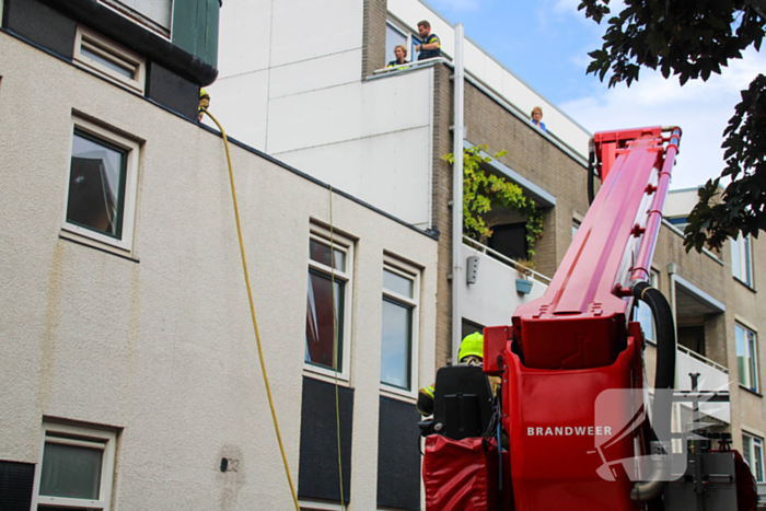 Veel rookontwikkeling bij brand op dak bij portiekwoning