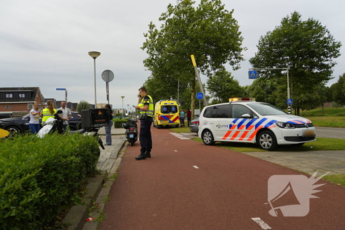 Scooterrijder komt ten val, ambulancepersoneel biedt hulp