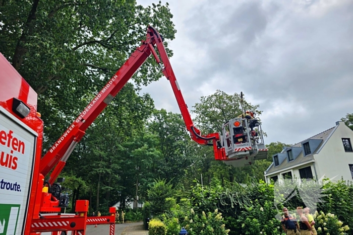 Brandweer verwijdert gevaarlijk hangende tak met hoogwerker