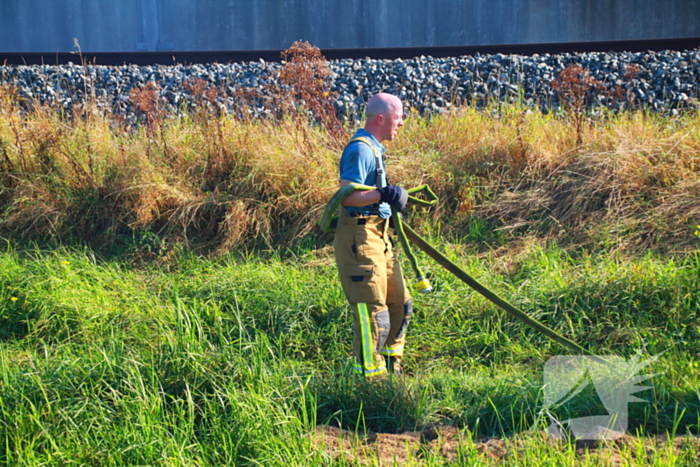 Tientallen meters bermbrand achter spoor moeilijk bereikbaar