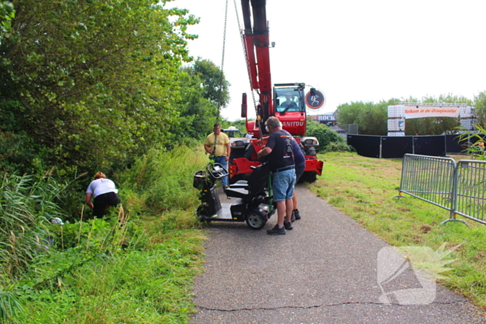 Man met scootmobiel in droge sloot: Jongens van Oranjevereniging bieden hulp