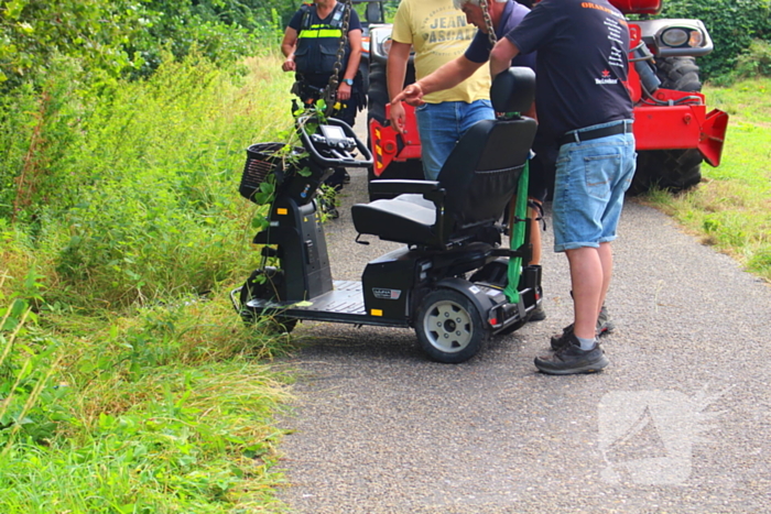 Man met scootmobiel in droge sloot: Jongens van Oranjevereniging bieden hulp