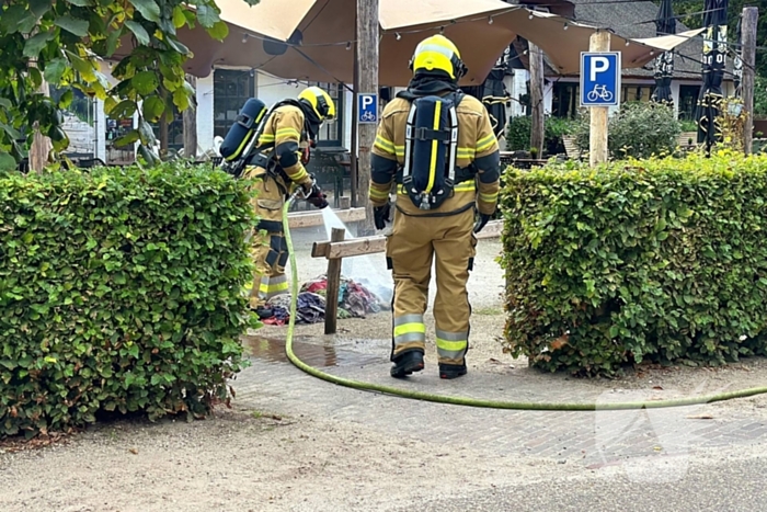 Brand in wasmand vol handdoeken bij restaurant