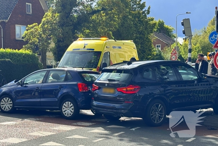 Twee voertuigen botsen op elkaar waarna een op een verkeerslicht klapt