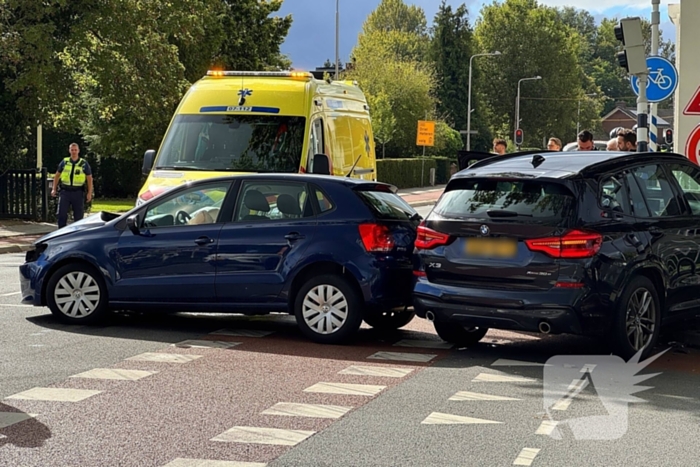 Twee voertuigen botsen op elkaar waarna een op een verkeerslicht klapt