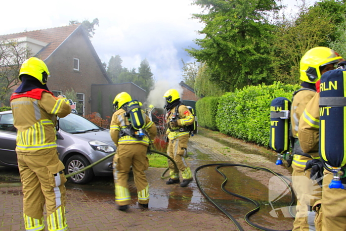 Personenauto vat vlam op oprit