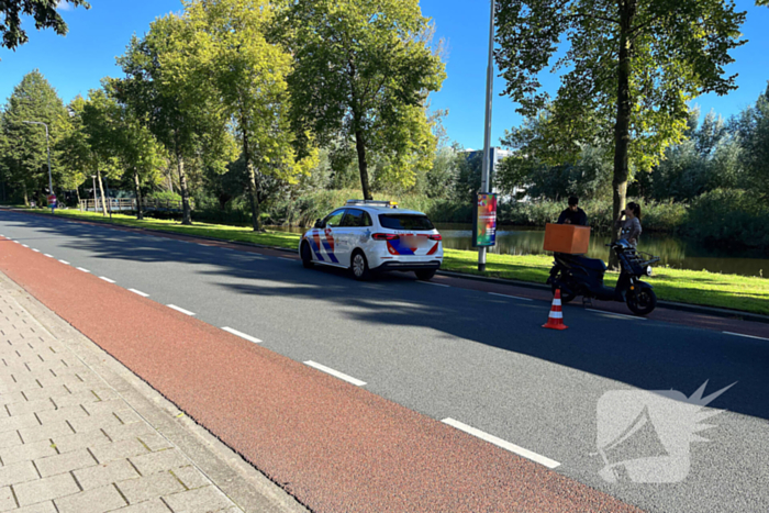 Bezorgscooter en fietser in botsing met elkaar