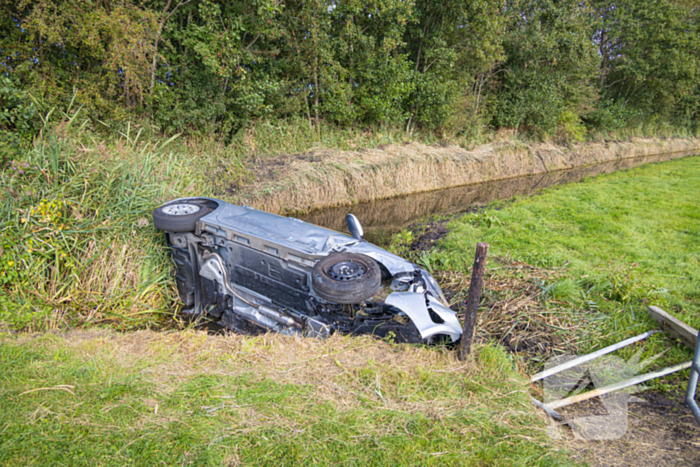 Omstanders halen automobilist uit te water geraakte auto