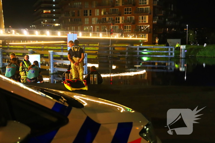 Persoon klimt op palen onder brug en word gebeten door politiehond