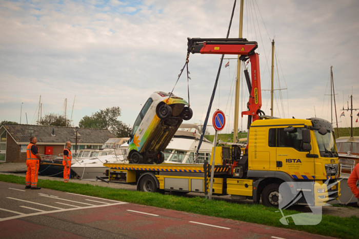 Auto rolt jachthaven in en gaat kopje onder