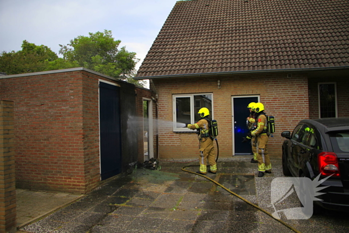 Brand in kliko slaat over op garagedeur