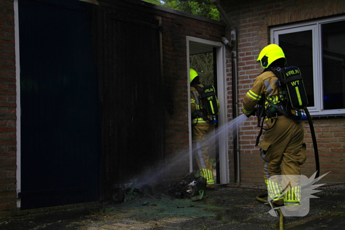 Brand in kliko slaat over op garagedeur