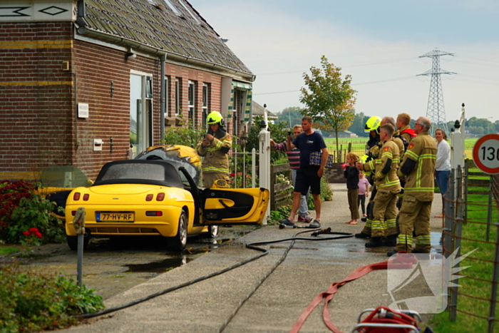 Personenwagen naast woning vliegt in brand