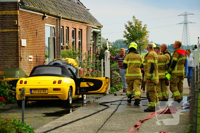 Personenwagen naast woning vliegt in brand