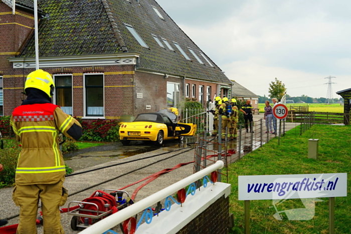 Personenwagen naast woning vliegt in brand