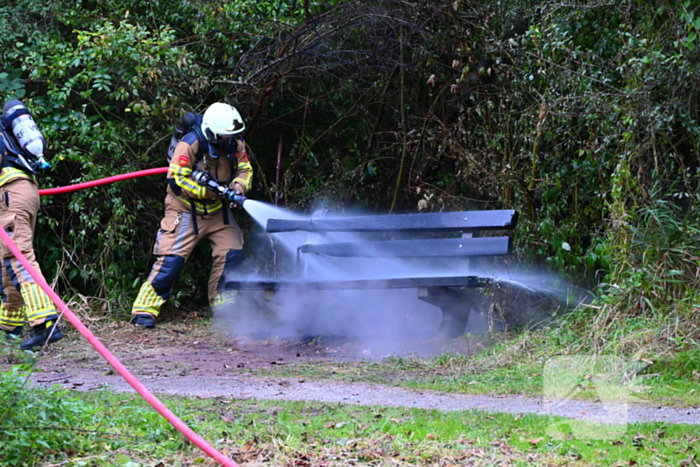 Brandweer blust brandende houten bank