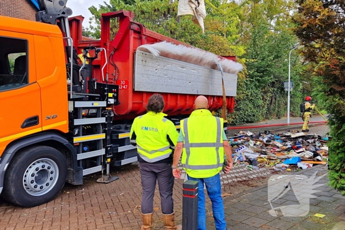 Containerwagen dumpt brandend afval op straat