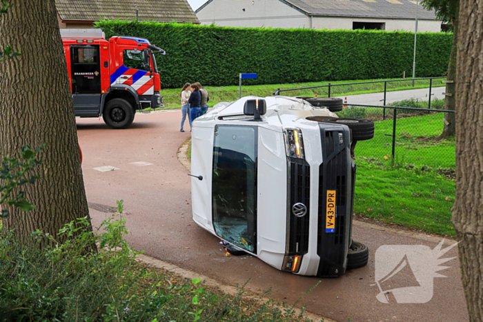 Bestelbus op zijn kant bij aanrijding