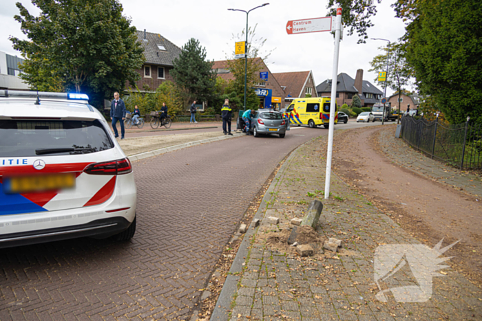 Automobilist ramt verkeersbord en lantaarnpaal