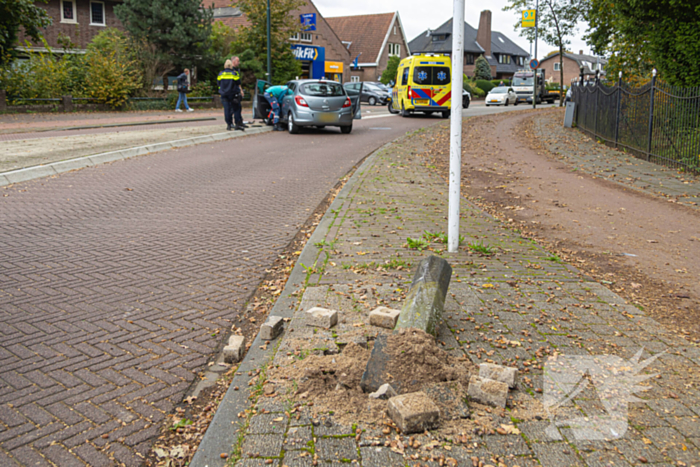 Automobilist ramt verkeersbord en lantaarnpaal