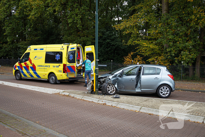 Automobilist ramt verkeersbord en lantaarnpaal