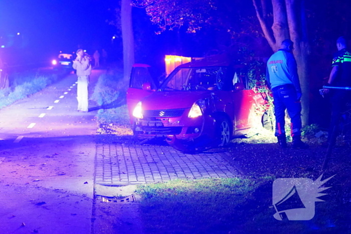 Auto raakt van de weg, botst tegen boom en eindigt in voortuin