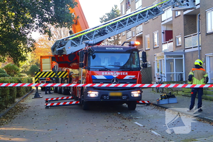 Persoon door hijskraan uit flatwoning getakeld