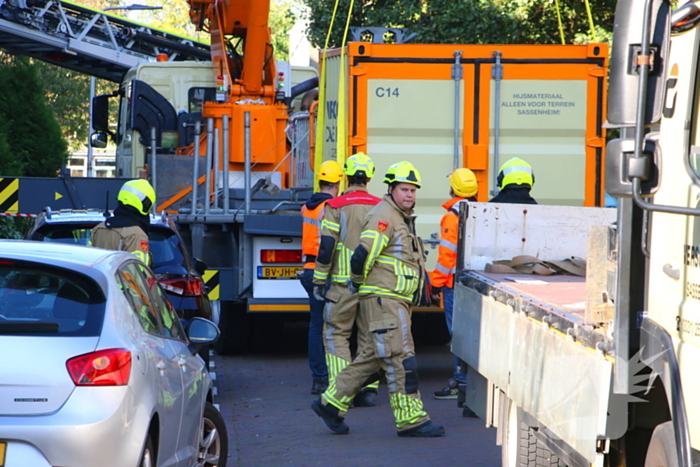 Persoon door hijskraan uit flatwoning getakeld