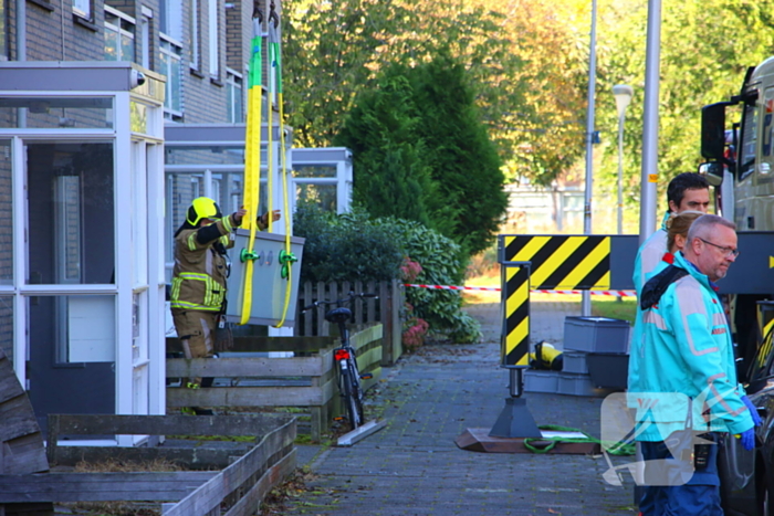 Persoon door hijskraan uit flatwoning getakeld