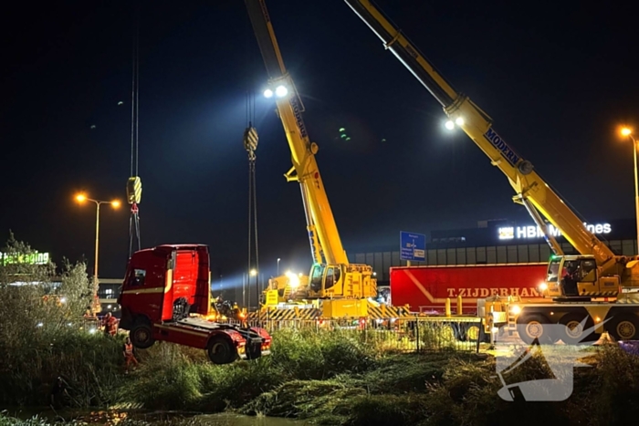 Te water geraakte vrachtwagen geborgen door grote hijskranen