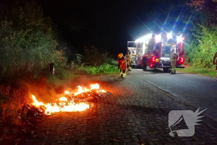 Brandweer dooft in brand gestoken afval