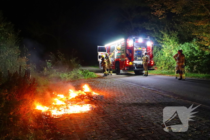 Brandweer dooft in brand gestoken afval