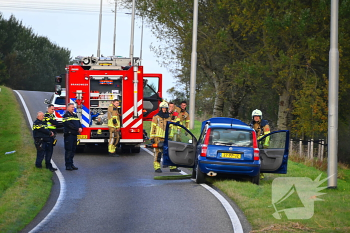 Personenauto vat vlam onder motorkap