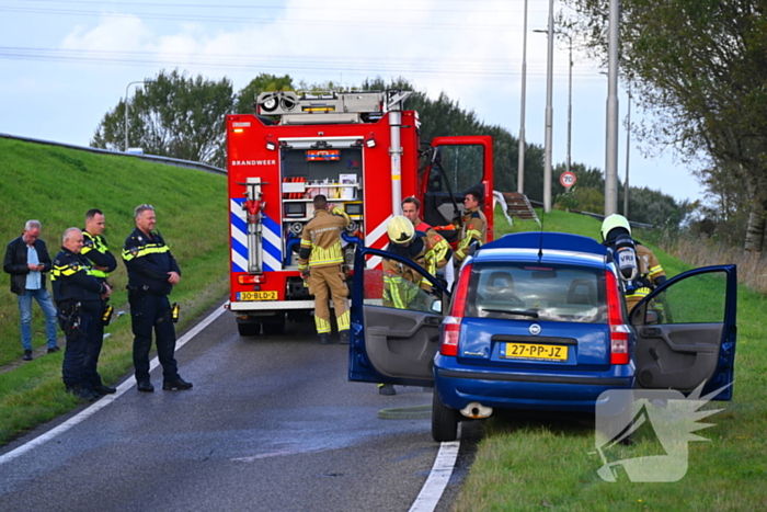 Personenauto vat vlam onder motorkap