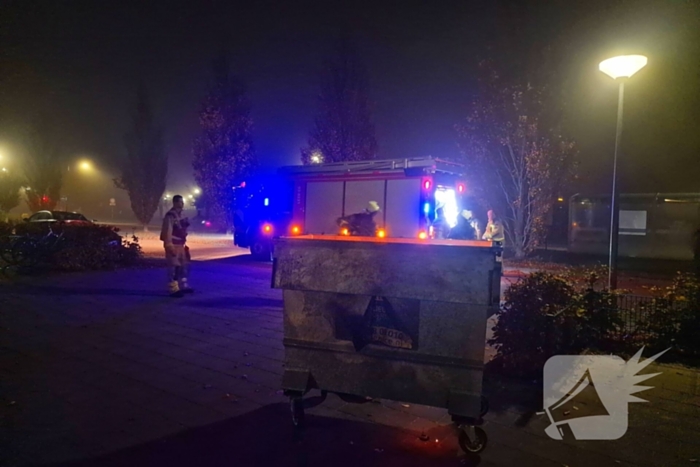 Brandweer blust brand in afvalcontainer